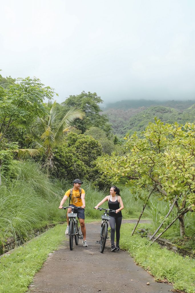 a man and a women cycling around Tembok, Bali.