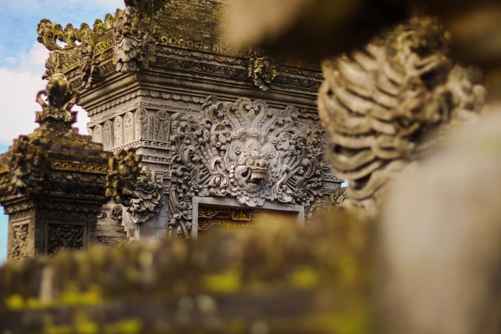 a close up of a wall filled with Balinese architecture with a sky in the background
